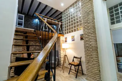 a room with a staircase and a brick wall at SH Casa de la Catedral. En el centro de la ciudad. in Cádiz