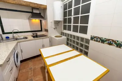 a small kitchen with white cabinets and a sink at SH Casa de la Catedral. En el centro de la ciudad. in Cádiz