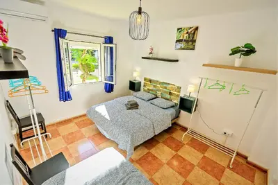 a small bedroom with a bed and a window at Plaza Polvorista 4-Bedroom Apartment w Balcony in El Puerto de Santa María