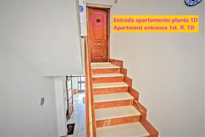 a wooden staircase in a room with a door at Plaza Polvorista 4-Bedroom Apartment w Balcony in El Puerto de Santa María