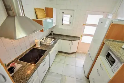 a small kitchen with a sink and a stove at Plaza Polvorista 4-Bedroom Apartment w Balcony in El Puerto de Santa María