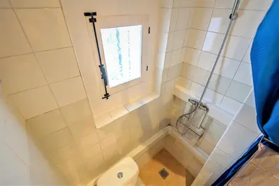 a bathroom with a toilet and a window at Plaza Polvorista 4-Bedroom Apartment w Balcony in El Puerto de Santa María