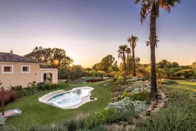 a backyard with a swimming pool and palm trees at Barceló Montecastillo Golf in Jerez de la Frontera