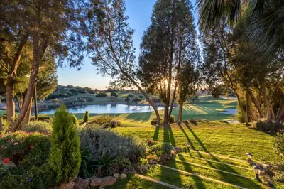 a view of a golf course with a pond and trees at Barceló Montecastillo Golf in Jerez de la Frontera