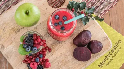 a cutting board with fruit and a drink on it at Barceló Montecastillo Golf in Jerez de la Frontera
