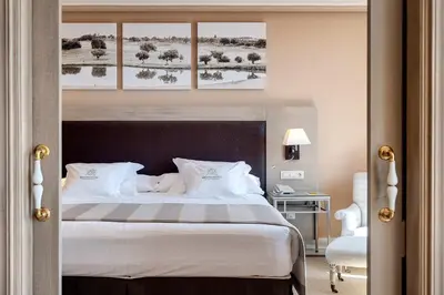a bedroom with a large bed with white pillows at Barceló Montecastillo Golf in Jerez de la Frontera