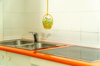 a kitchen sink with an orange counter top at Vistahermosa Palm in El Puerto de Santa María