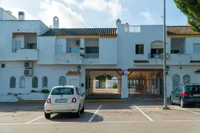 a white car parked in a parking lot in front of a building at Vistahermosa Palm in El Puerto de Santa María