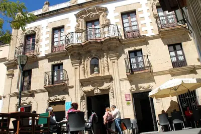 a group of people sitting outside of a building at Casa Palacio de los Leones in El Puerto de Santa María