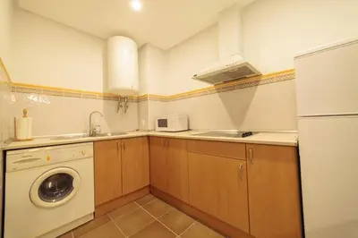 a kitchen with a sink and a washing machine at Casa Palacio de los Leones in El Puerto de Santa María