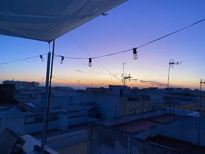 a view of a city from a rooftop at sunset at Ático Cádiz 360 in Cádiz