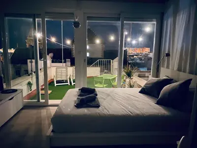 a bedroom with a bed with a view of a balcony at Ático Cádiz 360 in Cádiz