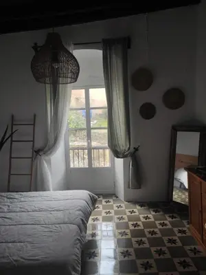 a bedroom with a bed and a large window at Calle Nueva in Arcos de la Frontera