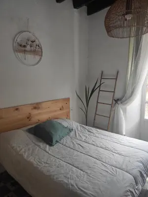 a bedroom with a bed with a wooden headboard and a ladder at Calle Nueva in Arcos de la Frontera