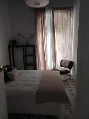 a bedroom with a bed and a chair and a window at Calle Nueva in Arcos de la Frontera