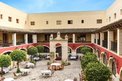 a courtyard with tables and chairs in a building at The Place Bodega Real by ALEGRIA in El Puerto de Santa María