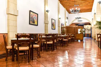 a dining room with wooden tables and chairs at The Place Bodega Real by ALEGRIA in El Puerto de Santa María