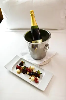 a bottle of champagne and a plate of food at The Place Bodega Real by ALEGRIA in El Puerto de Santa María