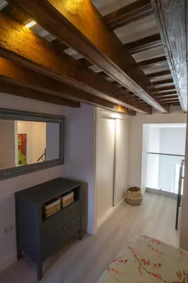 a bedroom with a bed and a dresser and a mirror at Apartamento Duplex casa Palacio rehabilitado centro El Puerto in El Puerto de Santa María