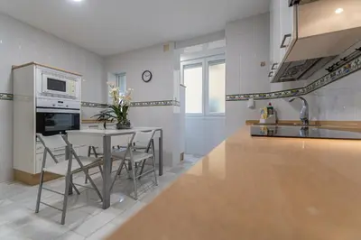 a kitchen with a table with chairs and a microwave at Apartamento El parador del boticario in Cádiz