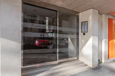 a reflection of a car in the window of a building at Apartamento El parador del boticario in Cádiz