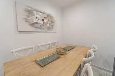 a dining room table with chairs and a painting on the wall at Apartamento El parador del boticario in Cádiz