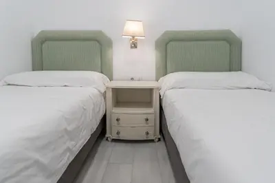 two beds sitting next to each other in a room at Apartamento El parador del boticario in Cádiz