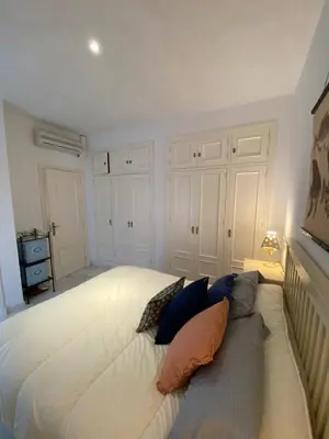 a white bed with pillows on it in a bedroom at Casa Rosa in Chiclana de la Frontera