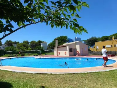a man standing next to a swimming pool at Casa Rosa in Chiclana de la Frontera