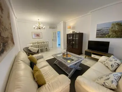 a living room with a couch and a table at Casa Rosa in Chiclana de la Frontera