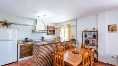 a kitchen with a wooden table and a refrigerator at Chalet Algar by Ruralidays in Algar