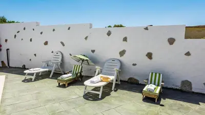a group of chairs sitting next to a wall at Chalet Algar by Ruralidays in Algar