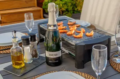 a table with a bottle of wine and a grill with sushi at Penthouse with Jacuzzi, and garaje Grupo AC Gestion in Cádiz