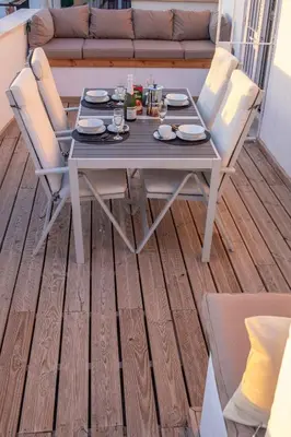 a table and chairs on a deck with a couch at Penthouse with Jacuzzi, and garaje Grupo AC Gestion in Cádiz
