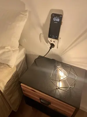 a cell phone on a table next to a bed at Penthouse with Jacuzzi, and garaje Grupo AC Gestion in Cádiz