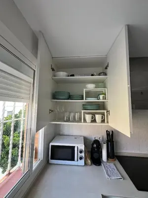 a kitchen with a microwave on a counter with a window at Golden Hour Grupo AC Gestión in Rota