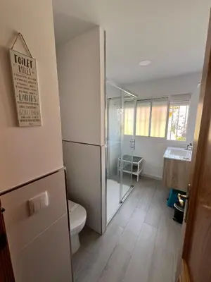 a bathroom with a toilet and a glass shower at Golden Hour Grupo AC Gestión in Rota