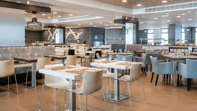 a restaurant with tables and chairs and a bar at Ilunion Calas de Conil in Conil de la Frontera