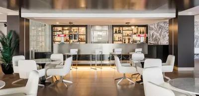 a restaurant with white chairs and tables and a bar at Ilunion Calas de Conil in Conil de la Frontera