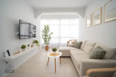 a white living room with a couch and a table at Apartamento Sanlúcar Sunset in Sanlúcar de Barrameda