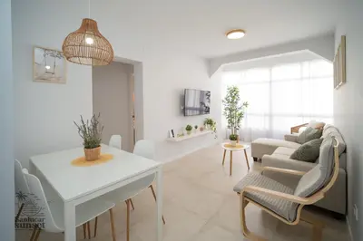 a white living room with a table and a couch at Apartamento Sanlúcar Sunset in Sanlúcar de Barrameda