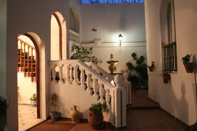 a hallway with a staircase in a house with potted plants at Brasilia in Chipiona
