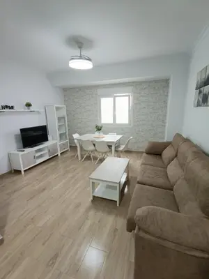 a living room with a couch and a table at Piso Avenida junto a la Playa in Cádiz