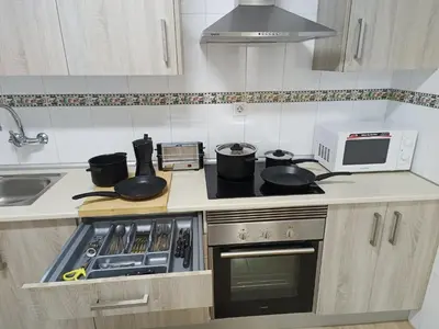 a kitchen with a stove with pots and pans on it at Piso Avenida junto a la Playa in Cádiz