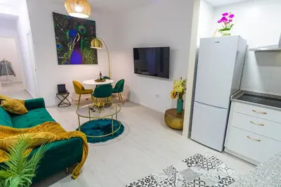 a living room with a green couch and a table at SH Rujacor Mare. Apartamento chic en la Viña in Cádiz