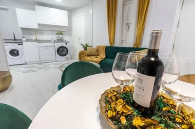 a bottle of wine sitting on a table with two glasses at SH Rujacor Mare. Apartamento chic en la Viña in Cádiz