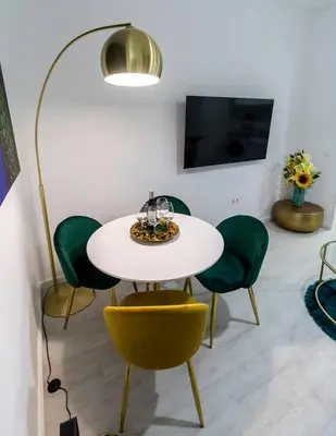a dining room with a table and green chairs at SH Rujacor Mare. Apartamento chic en la Viña in Cádiz