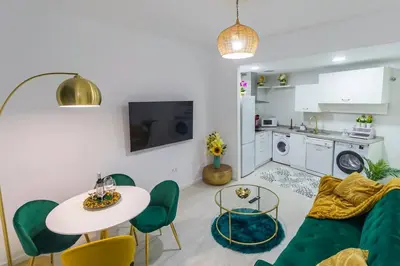 a living room with a green couch and a table at SH Rujacor Mare. Apartamento chic en la Viña in Cádiz