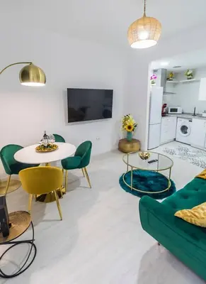 a living room with a green couch and a table at SH Rujacor Mare. Apartamento chic en la Viña in Cádiz