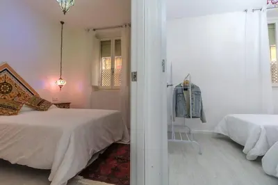 a white bedroom with a bed and a window at SH Rujacor Mare. Apartamento chic en la Viña in Cádiz